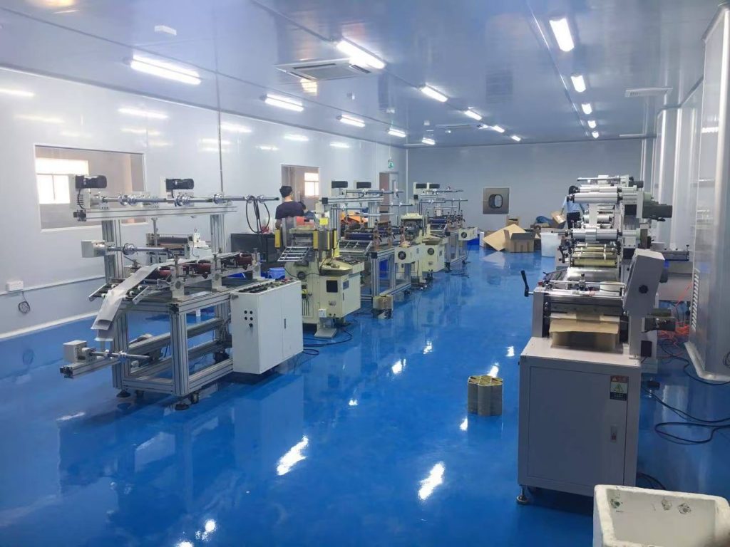 A high-precision die-cutting cleanroom workshop featuring advanced cutting machines, organized workstations, and a dust-free production environment. The facility specializes in manufacturing precision-cut components for electronics, automotive, medical, and industrial applications.